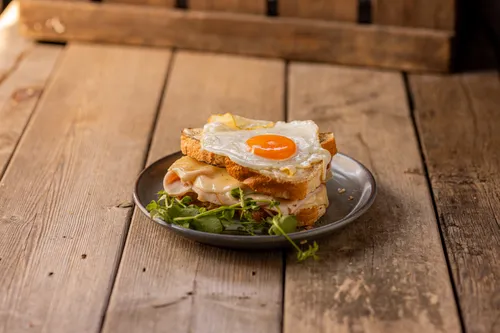 Tosti gegratineerd met bechamelsaus en kaas en een spiegel ei